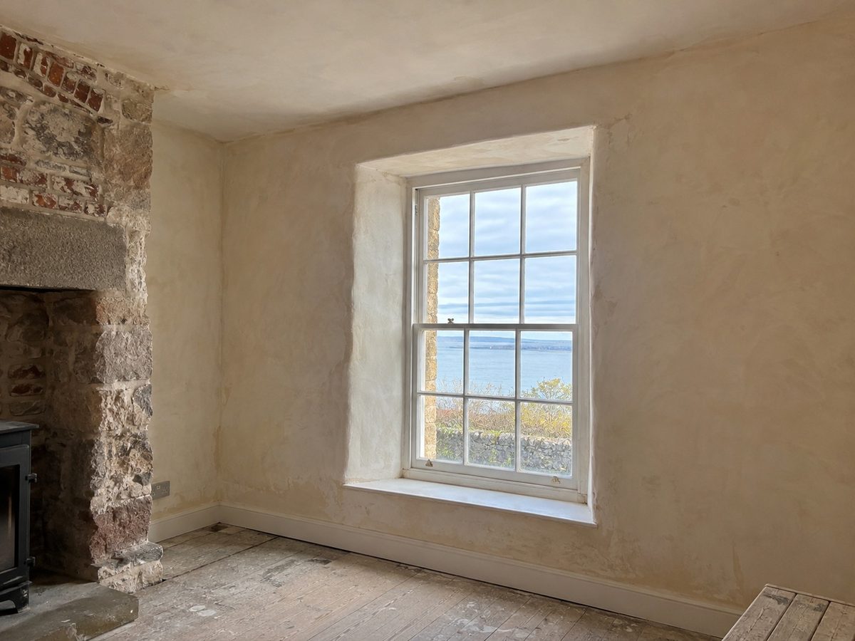 A large detached house with lime render on its elevation