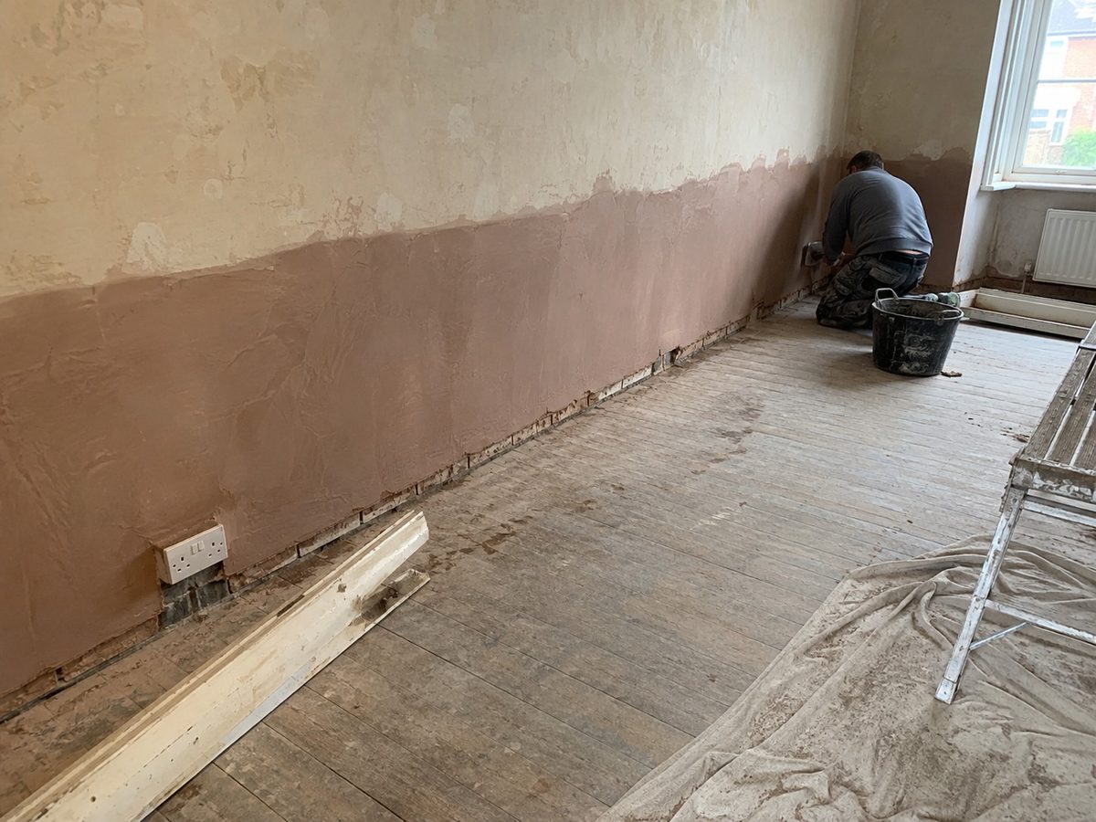The bottom metre of a hall wall replastered after damp treatment