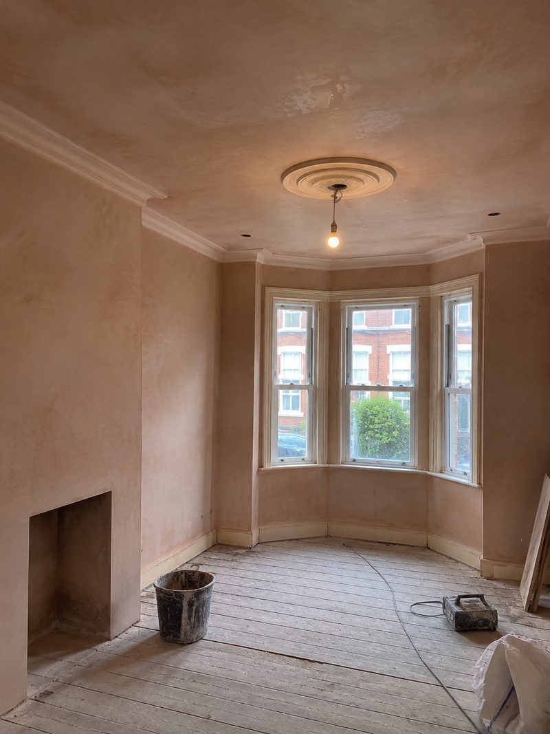 A plastered wall part finished, the fresh coat meeting the older surface